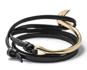 Detail of multi-layer black leather bracelet with a gold metal anchor hook clasp