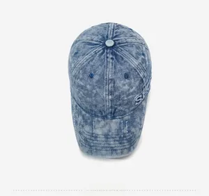 Detailed macro view of embroidered letter S on washed denim vintage baseball cap
