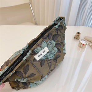 Macro detail of vintage floral canvas makeup bag with olive green fabric and zipper