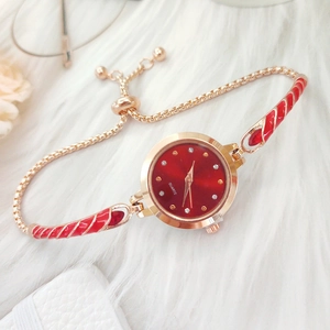 Elegant gold bracelet watch for women with a vibrant red dial and crystal hour markers