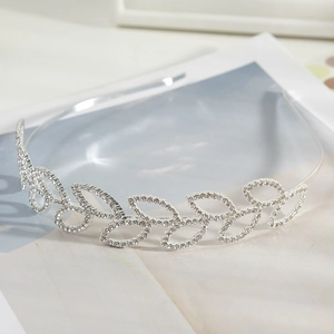 Detailed close-up of a sparkling silver leaf tiara with embedded white rhinestones