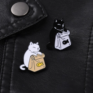 Close-up of cute black and white enamel cat pins on a black leather jacket texture