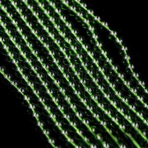 Macro shot of translucent green glass beads strings for DIY jewelry making and craft projects