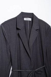 Detailed view of the notched lapel and grey pinstripe fabric texture on women blazer