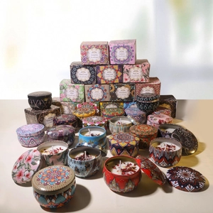 Scented soy wax candles with dried flowers in colorful metal tins and matching gift boxes