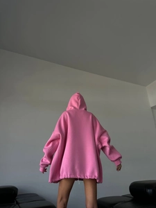 Close-up back view of oversized pink hoodie featuring dropped shoulders and ribbed cuffs
