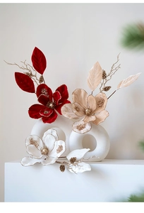 Velvet magnolia Christmas stems with glitter edges and gold pine cones in a ceramic vase