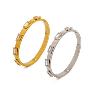 Detail of gold and silver stainless steel bangles set with rectangular zircon crystals