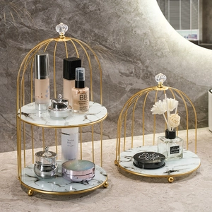 Golden birdcage iron makeup organizer with white marble trays for luxury vanity storage