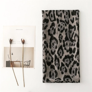 Detail shot of a grey and black leopard print scarf with a soft cotton-linen feel texture