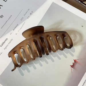 Detailed macro view of large matte brown claw clip with amber gradient on magazine