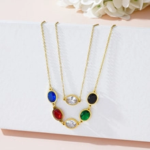Detail of 18K gold stainless steel chain with five colorful evil eye charms on a stand