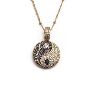 Golden Tai Chi Bagua pendant necklace with blue and clear zircon stones on white background