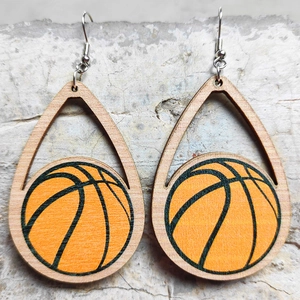 Dettaglio di orecchini a goccia in legno con motivi di pallacanestro arancione