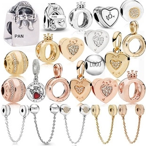 Macro display of diverse 3mm silver and gold jewelry charms and decorative safety chains