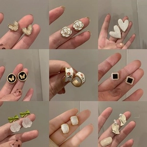 Vue détaillée de neuf paires de boucles d'oreilles vintage en peluche blanche et perles