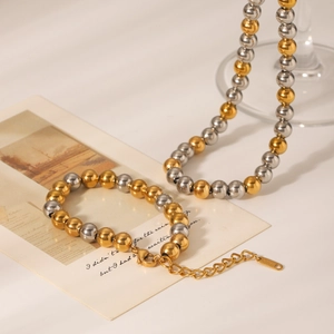 Macro détaillée d'un collier et bracelet en acier inoxydable bicolore avec fermoir solide