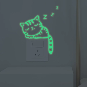 Glow-in-the-dark green sleeping cat sticker with Zzz design on a light switch