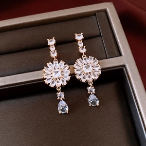 Macro shot of French style flower drop earrings with crystals and golden finish