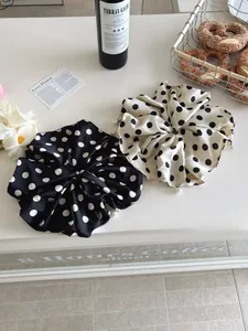 Detailed view of oversized polka dot satin scrunchies with elegant pearl accents