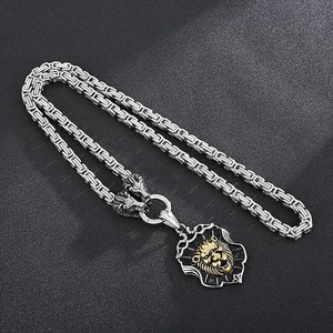 Detail of silver byzantine chain with golden lion head shield pendant on black background