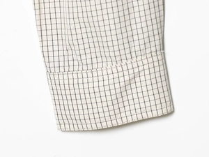 Detailed close-up of checkered nylon shirt cuff showing fine stitching and fabric texture