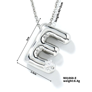 Macro view of silver balloon-style letter E pendant with white zircon and size details