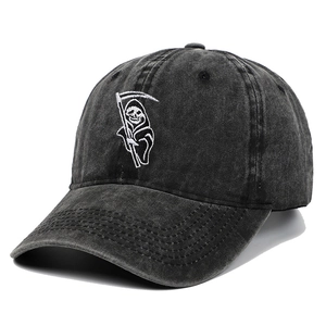 Washed black denim baseball cap with grim reaper embroidery in a 45-degree angle view