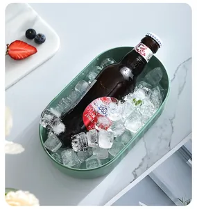Green ice bucket with beer and clear ice cubes on a marble counter for chilling drinks