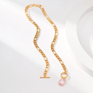 Minimalist gold necklace with raspberry pink glass pendant and OT buckle on white background