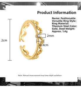 Detail of wave-shaped stainless steel ring with single cubic zirconia inlay and gold finish