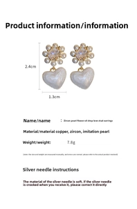 Detail view of heart drop earrings featuring zircon pearls and white enamel finish