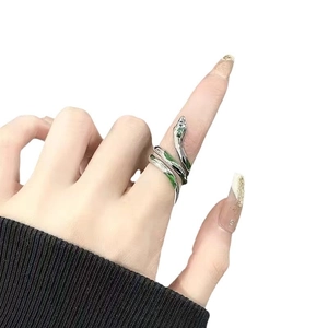 Bague serpent argentée ajustable avec émail vert portée sur l'index d'une femme