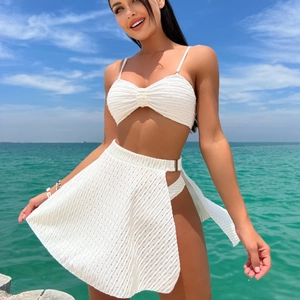 Three-piece white textured bikini set with ruffled bandeau top and matching sarong skirt