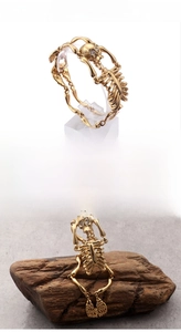 Detail of 18K gold plated stainless steel skull bracelet featuring clear crystal eyes