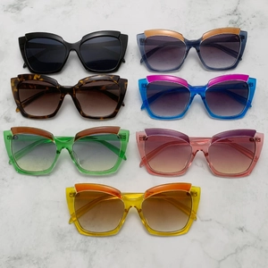 Collection of oversized cat eye sunglasses in seven vibrant gradient colors on marble