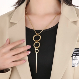 Detail of vintage gold-plated layered circle geometric pendant necklace on a khaki blazer
