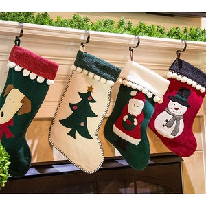 Detail of four festive Christmas stockings with cartoon patterns hanging on a fireplace
