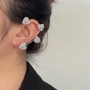 Close-up of sparkling heart-shaped silver ear cuff with inlaid crystals on a model