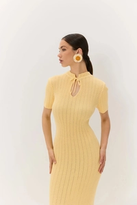 Dettaglio dell'abito in maglia giallo chiaro con lacci scavati e texture a costine
