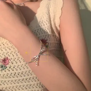 Close-up of a silver bow bracelet with sparkling pavé crystals on a woman's wrist