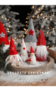 Detail of Christmas gnomes in red and grey felt on a wooden tray with warm bokeh lights