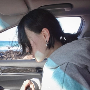 Woman wearing 925 sterling silver black onyx vase drop earrings in sunlight