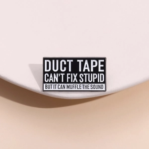 Makroaufnahme der Emaille-Anstecknadel mit Spruch 'Duct tape can't fix stupid' in Schwarz-Weiß