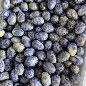 Macro view of polished egg-shaped blue sodalite stones with natural white marble texture