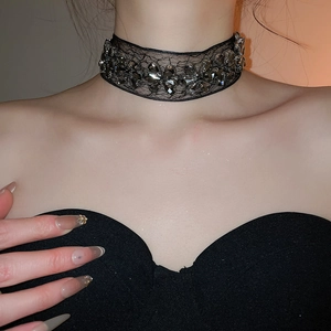 Détail d'un collier choker en dentelle gothique avec cristaux gris et fleurs