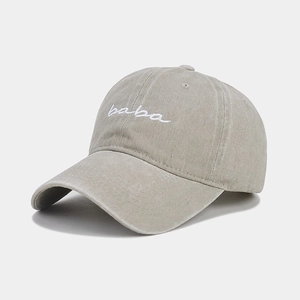 Close-up of vintage washed baseball cap featuring white BABA embroidery and textured cotton fabric