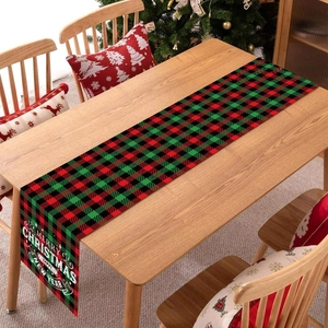 Red and green plaid Christmas table runner with festive holiday greeting on wood table