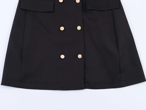 Détail d'une robe blazer noire ornée de boutons métalliques dorés à double boutonnage sophistiqués