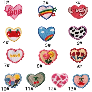 Detailed embroidery patches featuring colorful heart, floral, and fruit patterns on white